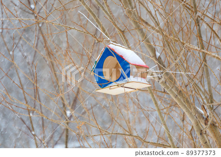 Birdhouse in the park in the winter season during a snowfall. Selective focus 89377373