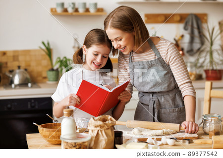 Positive family loving mother and daughter cooking together Positive family loving mother and daughter cooking together 89377542