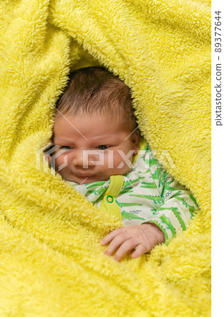 Infant baby wrapped in yellow blanket Infant baby wrapped in yellow blanket 89377644