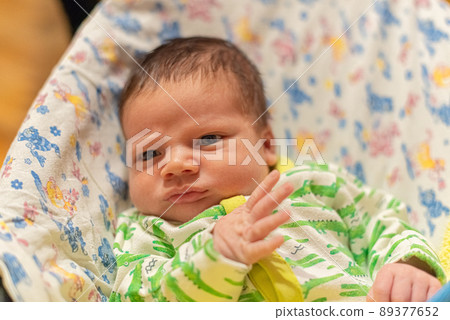Newborn baby lying in bed with raised arms Newborn baby lying in bed with raised arms 89377652