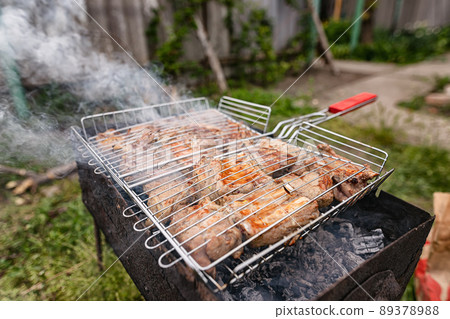 Cooking pickled butter on coals in an old backyard grill 89378988
