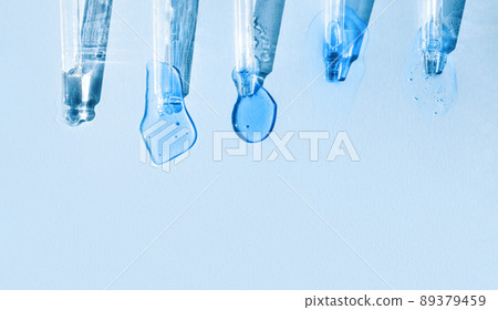 Pipettes with fluid hyaluronic acid on blue background in the sunlight. Cosmetics and healthcare concept. Dose of serum, retinol. Flat lay. Luxury beauty product presentation, macro. Web banner 89379459