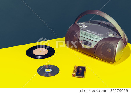 Colorful image of vintage radio player on bright yellow tablecloth isolated over dark green background Colorful image of vintage radio player on bright yellow tablecloth isolated over dark green background 89379699