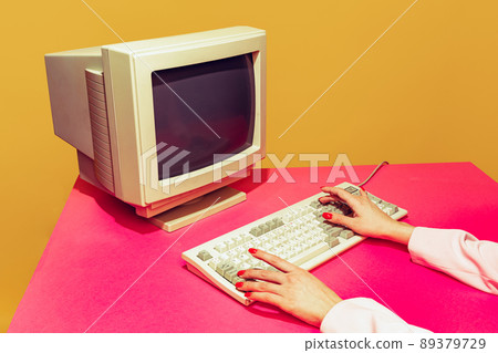 Colorful image of vintage computer monitor and keyboard on bright pink tablecloth over yellow background. Typing information 89379729