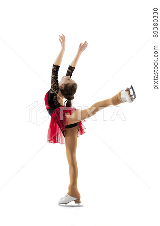 Portrait of little flexible girl, figure skating wearing stage attire posing isolated on white studio backgound. Concept of movement, sport, beauty. 89380330