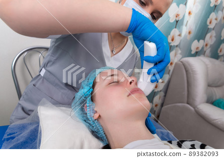 Young woman receiving electric galvanic anti-aging face spa massage at beauty salon. Young woman receiving electric galvanic anti-aging face spa massage at beauty salon. 89382093