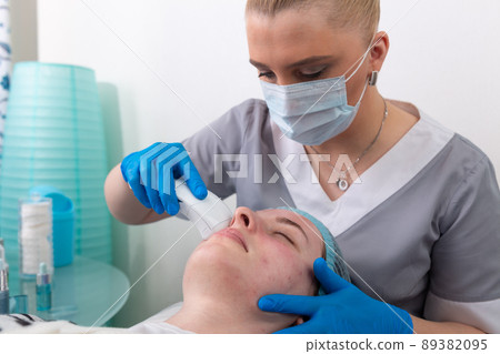 Young woman receiving electric galvanic anti-aging face spa massage at beauty salon. Young woman receiving electric galvanic anti-aging face spa massage at beauty salon. 89382095