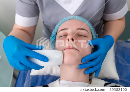 Young woman receiving electric galvanic anti-aging face spa massage at beauty salon. Young woman receiving electric galvanic anti-aging face spa massage at beauty salon. 89382100