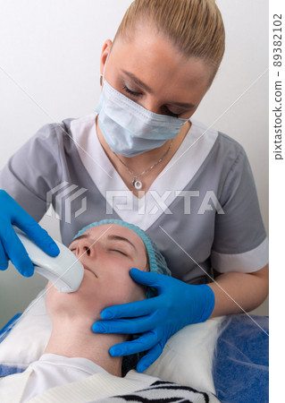 Young woman receiving electric galvanic anti-aging face spa massage at beauty salon. Young woman receiving electric galvanic anti-aging face spa massage at beauty salon. 89382102