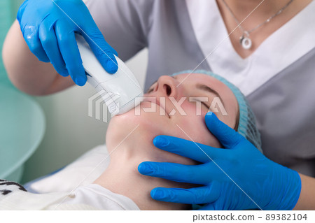 Young woman receiving electric galvanic anti-aging face spa massage at beauty salon. Young woman receiving electric galvanic anti-aging face spa massage at beauty salon. 89382104