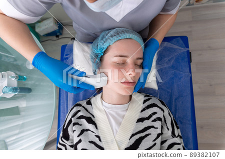 Young woman receiving electric galvanic anti-aging face spa massage at beauty salon. Young woman receiving electric galvanic anti-aging face spa massage at beauty salon. 89382107