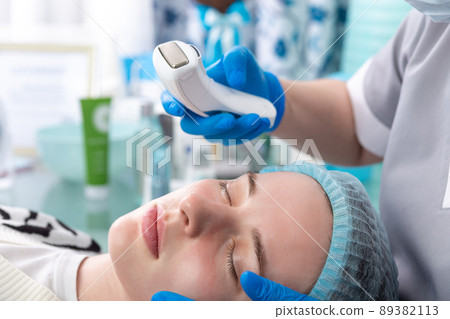 The cosmetologist adjusts the power of the device for galvanic massage. 89382113