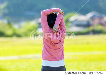 Japanese middle-aged woman exercising in an outdoor park Japanese middle-aged woman exercising in an outdoor park 89382262