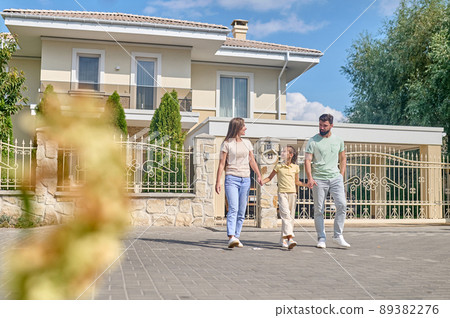 A young cute family walking in the street A young cute family walking in the street 89382276