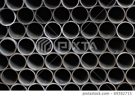 Maetallic pipes of the same diameter are neatly stacked. View of pipes from the front. Background Maetallic pipes of the same diameter are neatly stacked. View of pipes from the front. Background 89382715