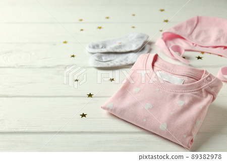 Concept of female baby clothes on white wooden background 89382978