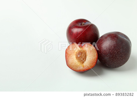 Plums with a half on a white background 89383282