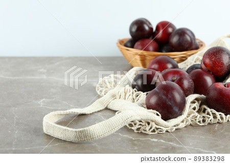 Concept of fruits with plums on gray textured table Concept of fruits with plums on gray textured table 89383298