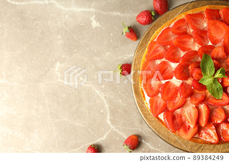 Wooden stand with strawberry tart on gray textured background 89384249