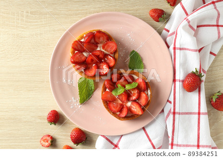 Concept of tasty food with strawberry tart on wooden table Concept of tasty food with strawberry tart on wooden table 89384251