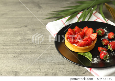 Concept of tasty food with strawberry tart on gray textured table 89384259