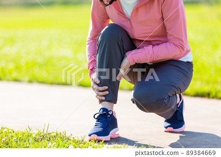 一名中年婦女抱著鍛煉時受傷的小腿 一名中年婦女抱著鍛煉時受傷的小腿 89384669