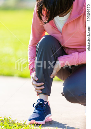 一名中年婦女抱著鍛煉時受傷的小腿 一名中年婦女抱著鍛煉時受傷的小腿 89384670