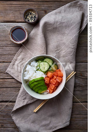 salmon poke bowl with fresh fish, rice, cucumber, avocado 89384713