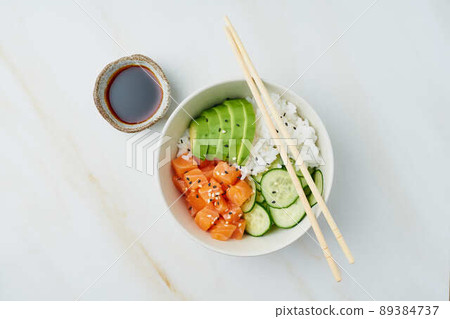 salmon poke bowl with fresh fish, rice, cucumber, avocado 89384737
