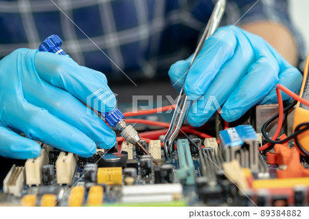Technician repairing inside of mobile phone by soldering iron. Integrated Circuit. the concept of data, hardware, technology. Technician repairing inside of mobile phone by soldering iron. Integrated Circuit. the concept of data, hardware, technology. 89384882