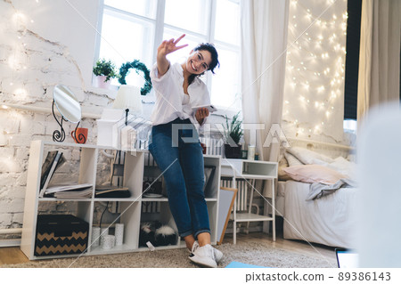 Happy woman showing v sign 89386143