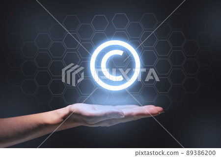 The concept of copyright and intellectual property as a projection of a hologram on the hand. 89386200