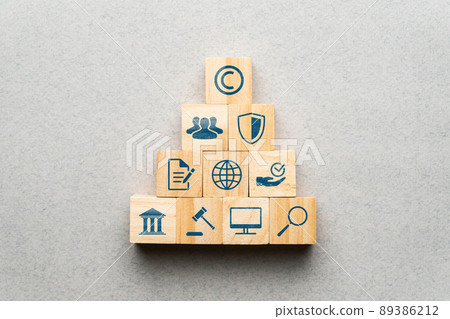 The concept of copyright and intellectual property. Protection, law and regulation icons on wooden blocks. 89386212