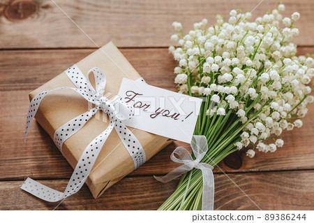 Lily of the valley and paper with text copy space on wooden background. For you with love Lily of the valley and paper with text copy space on wooden background. For you with love 89386244