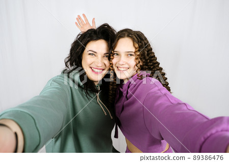 Portrait of happy mom and teen daughter spend time together. Teenage girl hugging her mother and having fun together Portrait of happy mom and teen daughter spend time together. Teenage girl hugging her mother and having fun together 89386476