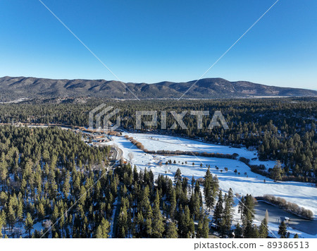 Aerial view over Big Bear Valey and Lake with now, South California, USA 89386513