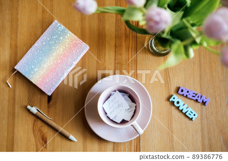 Affirmation, inspirational quotes concept. Paper with motivation affirmation message and inspirational quotes in pink tea cap on wooden table Affirmation, inspirational quotes concept. Paper with motivation affirmation message and inspirational quotes in pink tea cap on wooden table 89386776