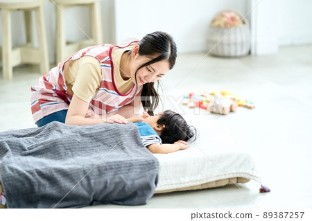 A female nursery teacher who puts her to sleep in a nursery school 89387257