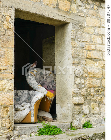 Trraditional view of an abandoned mountain village, stone wall, old furniture, pigeon Trraditional view of an abandoned mountain village, stone wall, old furniture, pigeon 89387347