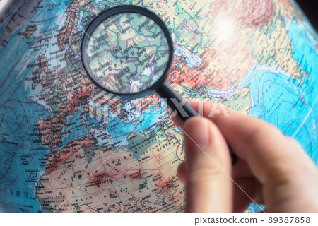 Hand with magnifying glass zoom Ukraine on world map with russian language. 89387858