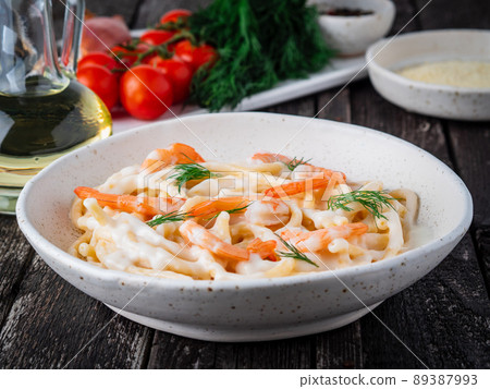 italian pasta spaghetti with shrimps, bechamel sauce and chopped dill 89387993