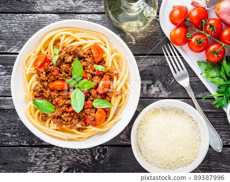 pasta bolognese with tomato sauce, ground minced beef, basil leaves on background 89387996