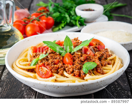 pasta bolognese with tomato sauce, ground minced beef, basil leaves on background pasta bolognese with tomato sauce, ground minced beef, basil leaves on background 89387997