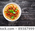 pasta bolognese with tomato sauce, ground minced beef, basil leaves on background 89387999