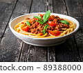 pasta bolognese with tomato sauce, ground minced beef, basil leaves on background 89388000