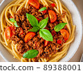 pasta bolognese with tomato sauce, ground minced beef, basil leaves on background 89388001