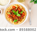 pasta bolognese with tomato sauce, ground minced beef, basil leaves on background 89388002