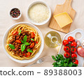 pasta bolognese with tomato sauce, ground minced beef, basil leaves on background 89388003