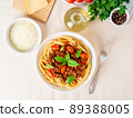 pasta bolognese with tomato sauce, ground minced beef, basil leaves on background 89388005