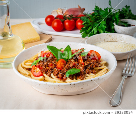 pasta bolognese with tomato sauce, ground minced beef, basil leaves on background 89388054